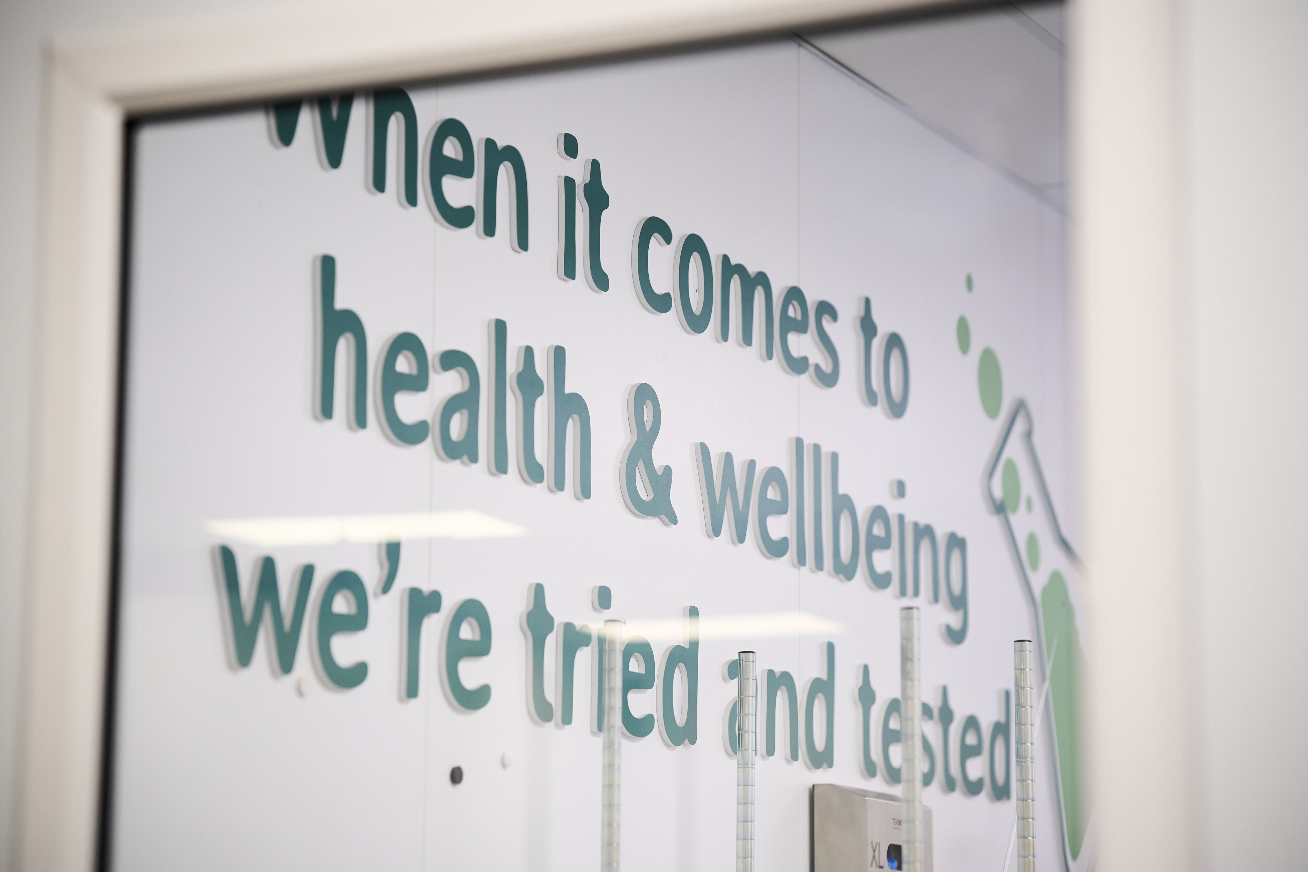 Mural in Quality office reads, When it comes to health & wellbeing we're tried and tested