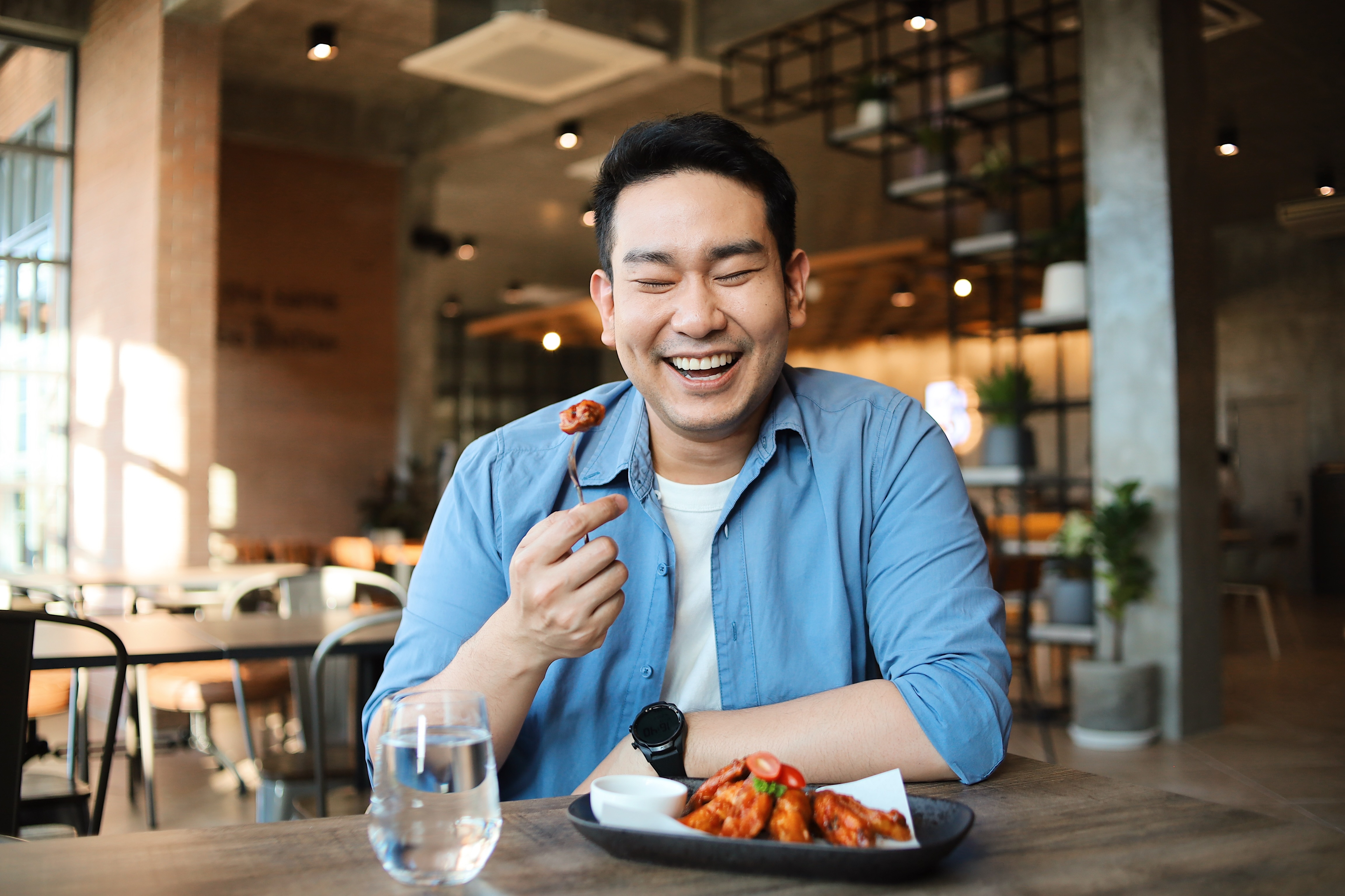 Smiling man eating in a restaurant