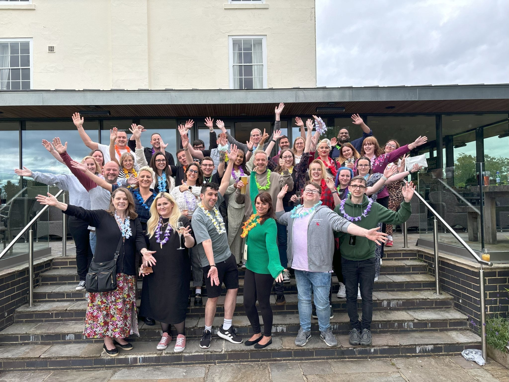 Group of colleague network members standing and waving