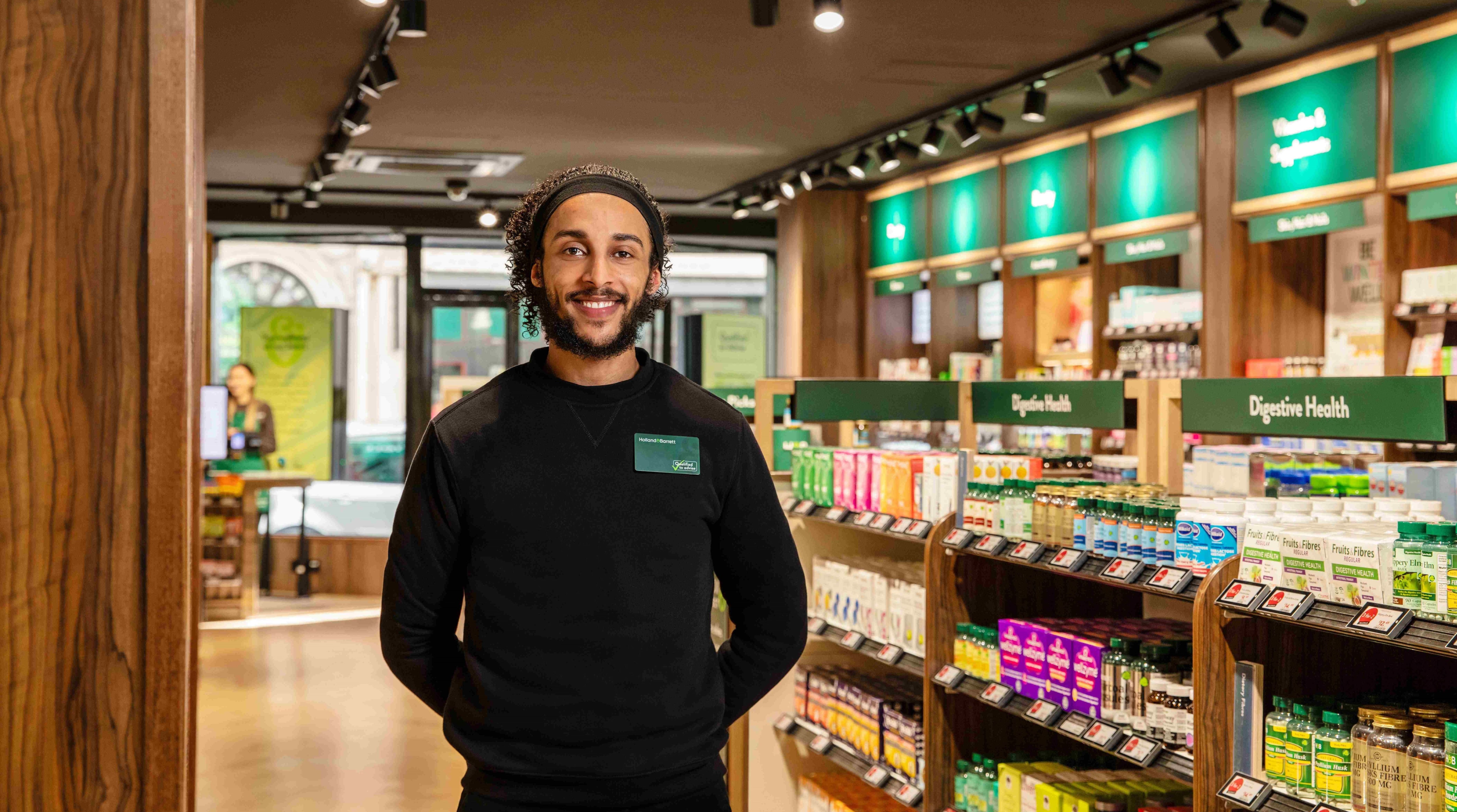 H&B colleague smiling and standing in store