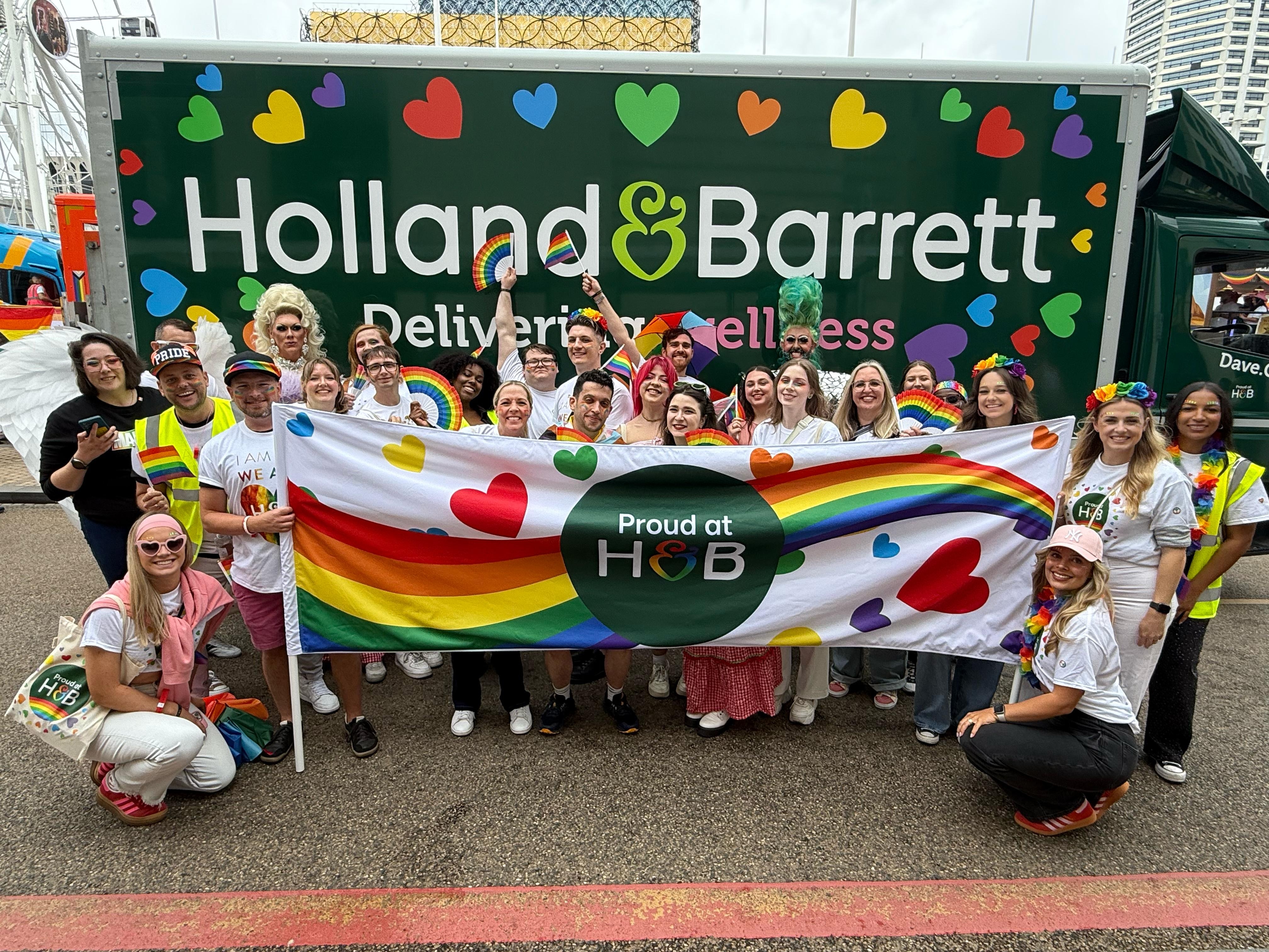Colleagues holding Proud at H&B sign 